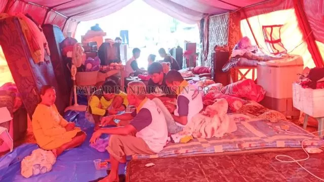 KEHIDUPAN TENDA: Suasana di tenda pengungsian di Jalan Guntung Manggis Ujung, Landasan Ulin, Banjarbaru, kemarin (15/1). Pengungsi telah bertahan di sana sejak 4 hari lalu. | Foto: SUTRISNO/RADAR BANJARMASIN