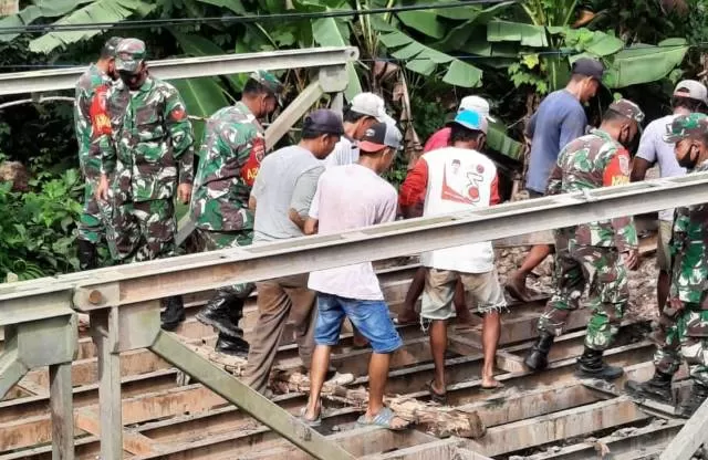 BONGKAR: Aparat bersama warga gotong royong membongkar material jembatan tak terpakai di Desa Tatakan. Material itu kemudian dibawa untuk perbaikan jembatan putus di Mataraman.