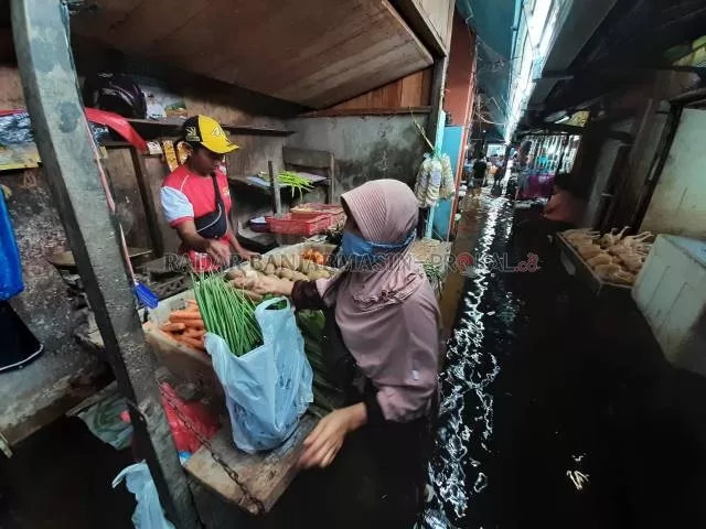 TERDAMPAK: Warga berbelanja di Pasar Kuripan. Tampak lorong pasar juga terendam air. | Foto: Wahyu Ramadhan/Radar Banjarmasin