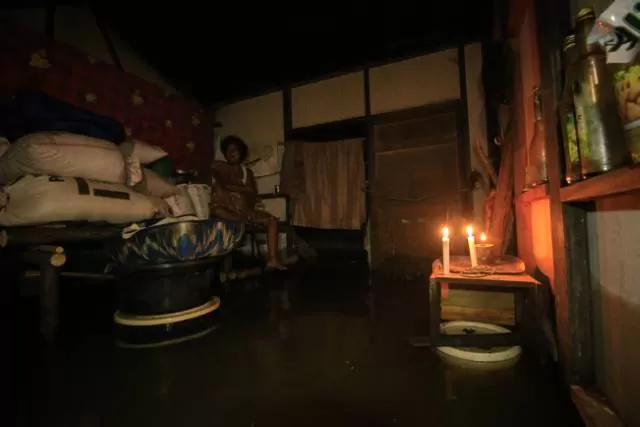 GELAP DAN BASAH: Sejunlah warga di Sungai Bakung, Kecamatan Sungai Tabuk, Kabupaten Banjar, memilih bertahan di rumah meski banjir menggenang. Sejumlah kawasan bak kota mati karena kondisi gelap gelita dan sepi aktivitas warga. | FOTO: MUHAMMAD RIFANI/RADAR BANJARMASIN