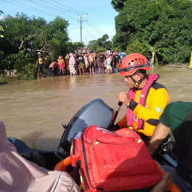 BANTU WARGA: Relawan dari Tanah Bumbu ikut membantu evakuasi warga terdampak banjir.