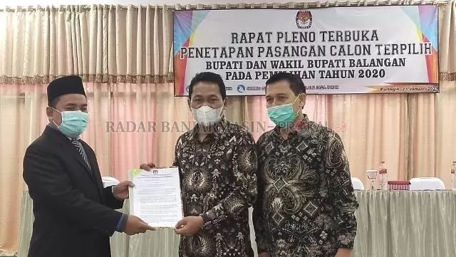 PENETAPAN : Ketua KPU Balangan Saripani (kiri) menyerahkan berita acara penetapan kepada pasangan HAS |  FOTO: WAHYUDI/RADAR BANJARMASIN.
