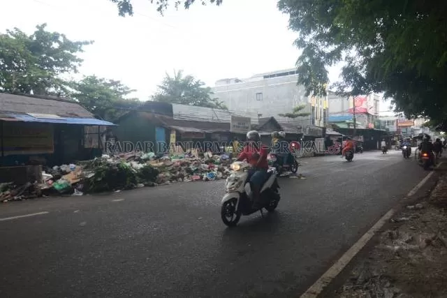 SISA BANJIR: Sampah meluber, hampir memakan separuh badan jalan. Foto diambil di Jalan Veteran, kemarin (25/1).| FOTO: WAHYU RAMADHAN RADAR BANJARMASIN