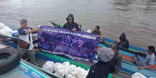 PEDULI: Ditemani relawan, pengurus Hiswana Migas berbagi nasi bungkus di Sungai Tabuk, Kabupaten Banjar, Selasa (26/1) pagi.