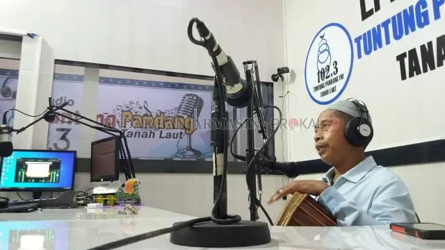 SIARAN: Syahrani AR saat membawakan siaran madihin di Radio Tuntung Pandang FM, Kamis (21/1). | Foto: Budian Noor/Radar Banjarmasin
