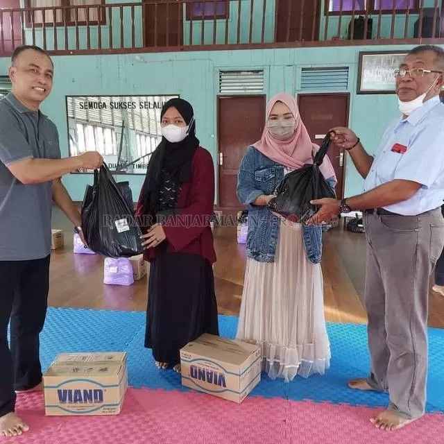 SOLIDARITAS: Ketua Umum TI Kalsel Bambang Supriyadi (kanan) didampingi Sekretaris Umum Jufhari (kiri) menyerahkan bantuan paket sembako di Gedung Taekwondo Kalsel kepada perwakilan taekwondoin yang terdampak banjir, Sabtu (30/1).