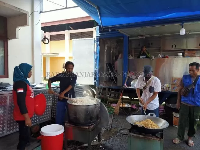 MASAK TERUS: Dapur umum yang berada di posko baru depan kantor BPBD Batola terus memasak nasi bungkus untuk pengungsi korban banjir. | Foto: Ahmad Mubarak/Radar Banjarmasin