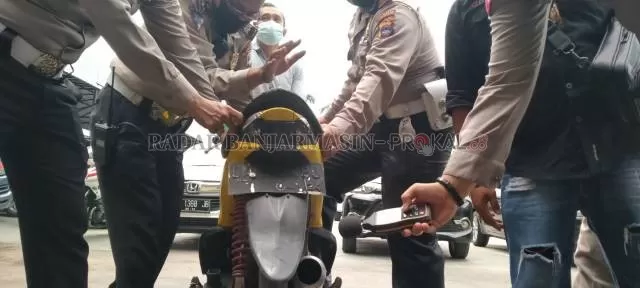UJI COBA: Anggota Satlantas Polresta Banjarmasin mencoba sound level meter ke motor sitaan dengan knalpot brong. | FOTO: MAULANA/RADAR BANJARMASIN