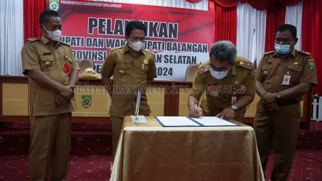 PENYERAHAN : Pj Sekdakab Balangan, Akhriani menandatangani berita acara serah terima jabatan Bupati Balangan. | FOTO: WAHYUDI RADAR BANJARMASIN.