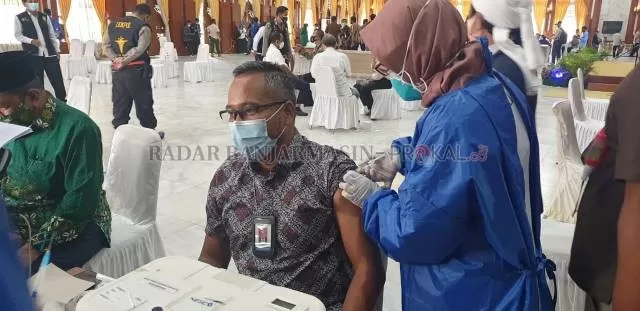 AGAR IMUN: Pemimpin Redaksi Radar Banjarmasin, Toto Fachrudin saat menerima vaksin dalam pembukaan vaksinasi Covid-19 tahap kedua di Mahligai Pancasila Banjarmasin, kemarin. | FOTO: SURIANSYAH ACHMAD/RADAR BANJARMASIN