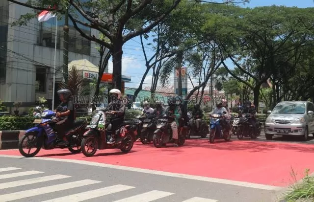 RUANG HENTI: Di lampu merah Jalan Lambung Mangkurat, kini ada marka merah. Itu ruang henti kendaraan, khusus untuk pesepeda motor. | FOTO: TIA LALITA NOVITRI/RADAR BANJARMASIN