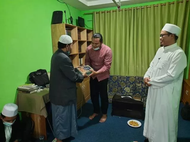 KITAB: Pimpinan Pondok Tahfizh Madinatul Quran Ustaz M Nasir menyerahkan kitab kepada santri Ma’had Darul Ma’arif Banjarmasin disaksikan Guru Wahyudi Ibnu Yusuf. | Foto: MDM for Radar Banjarmasin