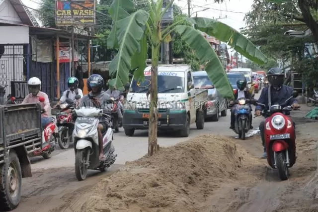 PENANDA LUBANG JALAN: Pohon pisang ini semakin mempersulit pengendara yang melintas di Jalan Tembus Perumnas. Foto diambil kemarin (16/3) pagi. | FOTO: WAHYU RAMADHAN/RADAR BANJARMASIN