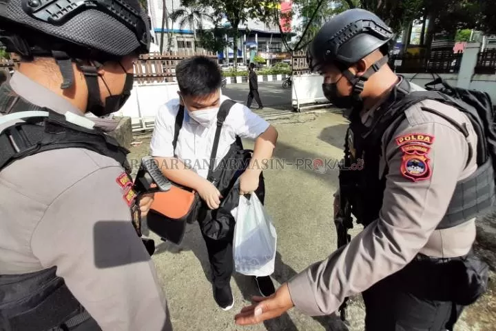 WASPADA: Polisi memeriksa barang bawaan jemaat yang hendak memasuki Gereja Batu di Banjarmasin pada saat sterilisasi menjelang ibadah misa. | FOTO: WAHYU RAMADHAN/RADAR BANJARMASIN