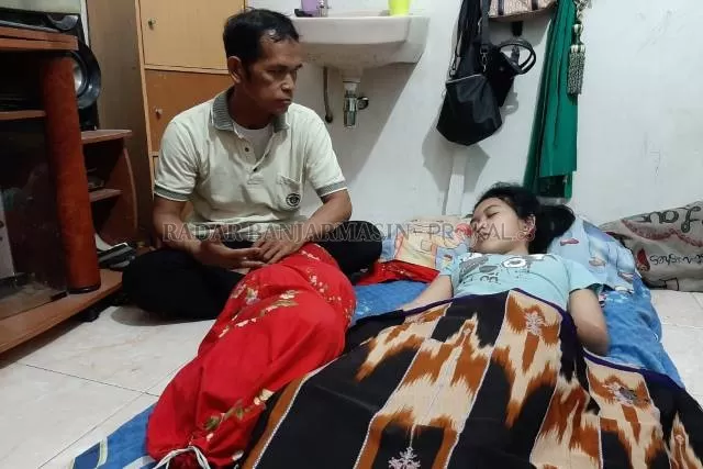 TAK TEGA: Mulyadi memandangi putrinya, Siti Raisa Miranda yang tertidur sejak awal April tadi. Gadis 16 tahun itu menderita kelainan langka Kleine-Levin syndrome (KLS). | FOTO: WAHYU RAMADHAN/RADAR BANJARMASIN