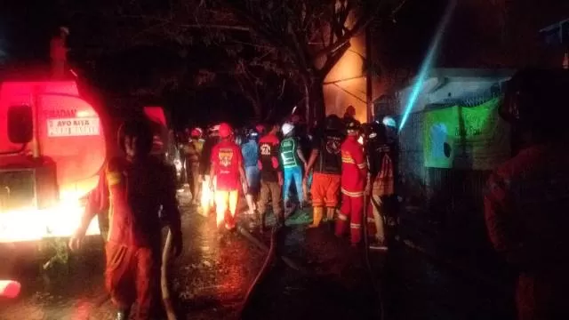 MELEDAK: Petugas pemadam kebakaran bersama warga Desa Sungai Taib bahu membahu memadamkan api.