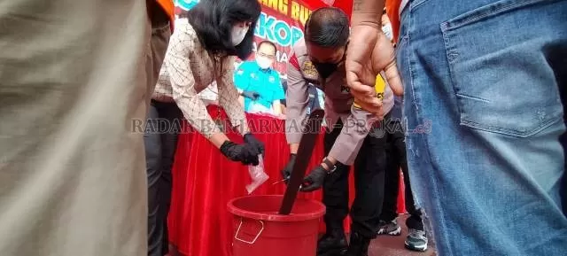 PEMUSNAHAN: Kapolresta Banjarmasin Kombes Pol Rachmat Hendrawan mencampurkan sabu ke ember berisi air deterjen. | FOTO; MAULANA/RADAR BANJARMASIN