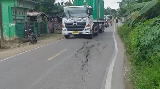 BERBAHAYA: Kendaraan pengangkut beban berat ketika melintas di jalan Tanjung-Kelua yang rusak.