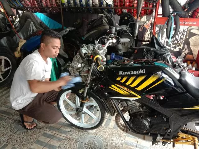 FOKUS: Madan menggarapo motor milik pelanggan di bengkelnya di kawasan Sungai Andai Banjarmasin.