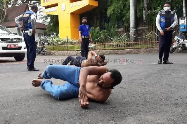 SANKSI FISIK: Dua polisi cepek yang diciduk Dishub dari Jalan Ahmad Yani km 6 diberi hukuman fi sik di lapangan Balai Kota Banjarmasin, kemarin (24/5) sore.