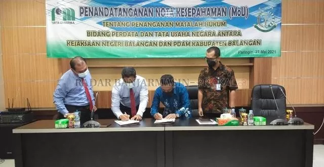 KERJA SAMA : Plt Direktur PDAM Kabupaten Balangan bersama Kajari Balangan saat menandatangani MoU. | FOTO: WAHYUDI/RADAR BANJARMASIN.