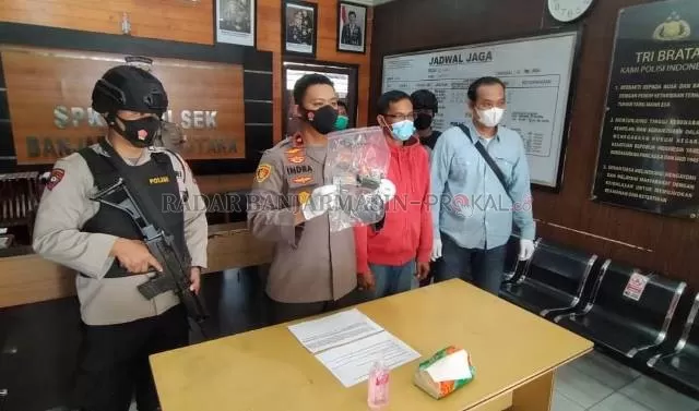 JADI PELAJARAN: Kapolsek Banjarmasin Utara Kompol Indra Agung Perdana menunjukkan airsoft gun milik MA (kanan mengenakan hoodie). | FOTO: MAULANA/RADAR BANJARMASIN