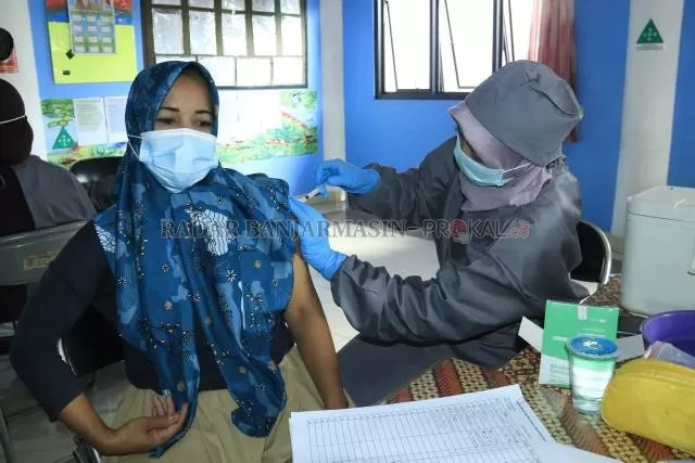 SYARAT WAJIB: Seorang guru di Banjarbaru saat divaksin beberapa waktu lalu. Pembelajaran tatap muka mempersyaratkan vaksinasi bagi para guru. | FOTO: DOK/RADAR BANJARMASIN