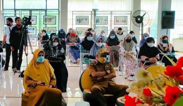 MOMEN: Irza Setiawan menyerahkan karya buku ke Kepala Dispersip HSU Lailatannur. | Foto: Muhammad Akbar/Radar Banjarmasin