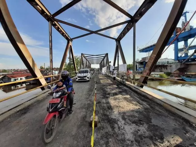 BAKAL DIBONGKAR: Pengendara melintas di Jembatan Lama Sungai Alalak, kemarin. Hampir rampungnya jembatan baru membuat jembatan lama mendesak dibongkar. \ FOTO: M OSCAR FRABY/RADAR BANJARMASIN