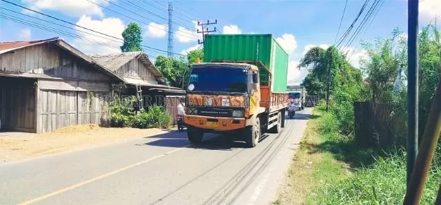 KENA IMBAS: Truk-truk besar melintasi jalan trans Kalimantan di Kota Amuntai. | Foto: Muhammad Akbar/Radar Banjarmasin