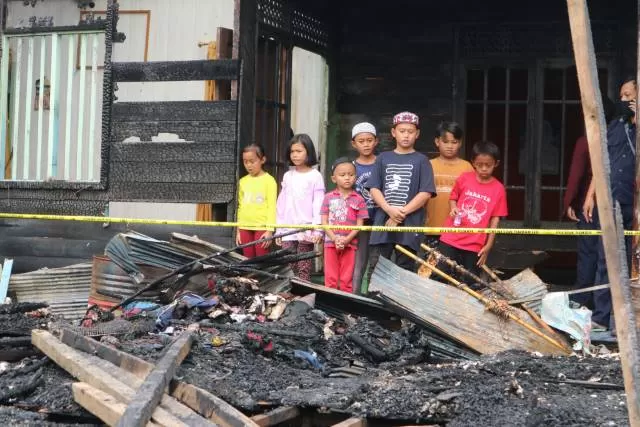 TRAGIS: Para bocah di Desa Belanti Raya memandang haru sisa kebakaran Senin (12/7) tadi. Di sinilah dua teman mereka terpanggang api.