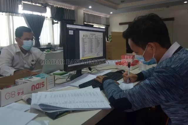 MONITOR: Pegawai BKD dan Diklat Banjarmasin memantau data pelamar seleksi CPNS pemko yang masuk. | FOTO: WAHYU RAMADHAN/RADAR BANJARMASIN