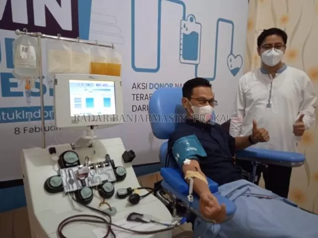 DONOR PLASMA: Kepala Unit Donor Darah PMI Kota Banjarmasin Aulia Ramadhan Supit berpose di samping pasien yang mendonorkan Plasma konvalesen.