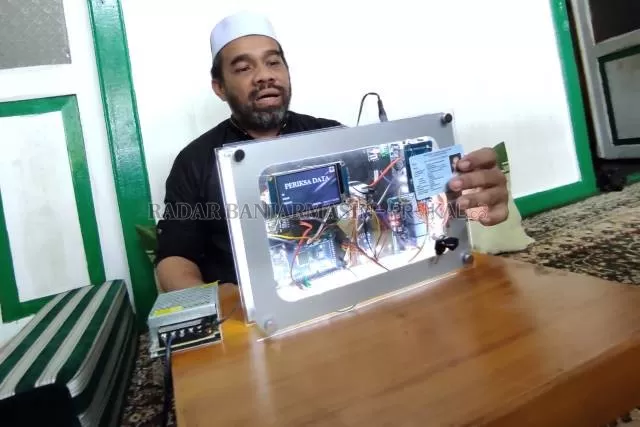 HASIL OTODIDAK: Habib Fathur menunjukkan cara penggunaan Smart Checker dengan data pribadi dari e-KTP miliknya sendiri. | FOTO: WAHYU RAMADHAN/RADAR BANJARMASIN