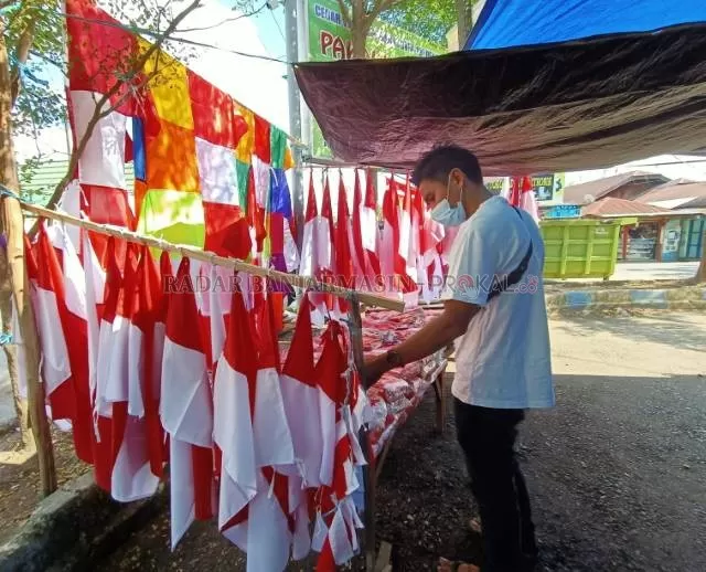 MASIH SEPI: Lapak bendera dadakan Rina, satu-satunya berjualan bendera di Pasar Marabahan. | Foto: Ahmad Mubarak Radar Banjarmasin.