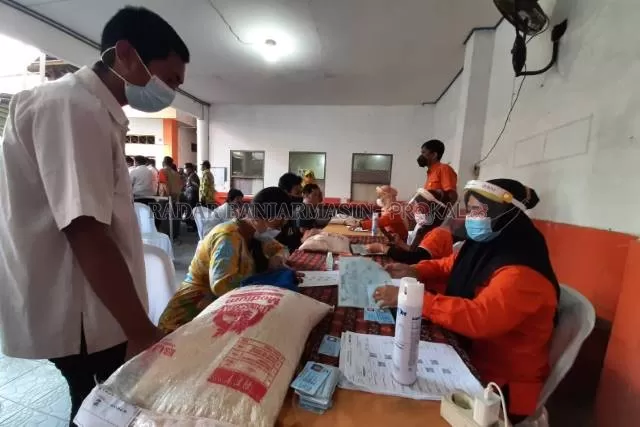 BANSOS: Penyaluran bantuan beras dan uang tunai untuk warga terdampak PPKM di kantor PT Pos Indonesia cabang Banjarmasin. | FOTO: WAHYU RAMADHAN/RADAR BANJARMASIN
