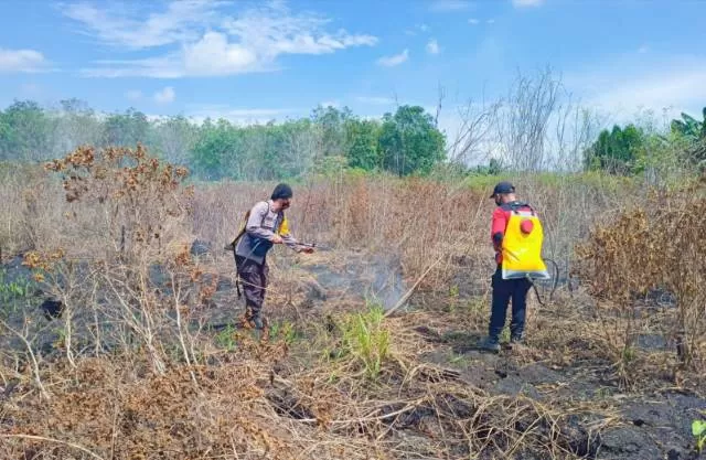 PADAMKAN: Anggota Manggala Agni dan Aiptu Rofik saat melakukan pemadaman lahan gambut dengan menggunakan semprotan portabel. | Foto: Aiptu Rofik untuk Radar Banjarmasin