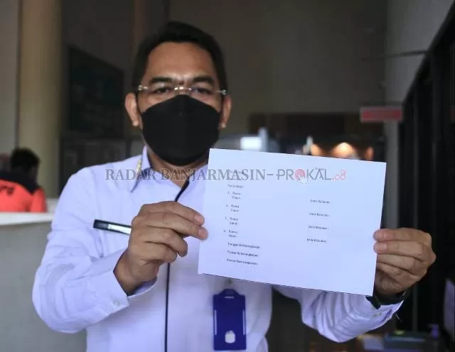SYARAT KHUSUS: Kepala Pelaksana BPBD Banjarbaru, Zaini Syahranie menunjukkan form permohonan surat keterangan penerbangan untuk anak-anak yang tidak bisa vaksin. | Foto: Muhammad Rifani/Radar Banjarmasin
