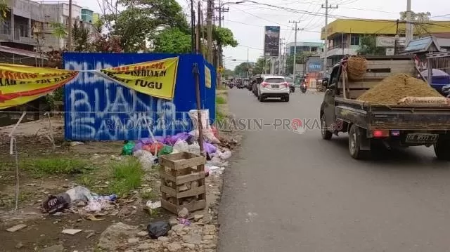 JADI KUMUH: Meski sudah dipagar dan dipasangi spanduk larangan, tetap saja sampah menumpuk di eks TPS Sutoyo. | FOTO: ENDANG SYARIFUDDIN/RADAR BANJARMASIN