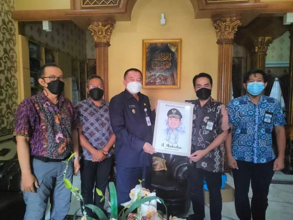 PENUH KEAKRABAN: Wakil Gubernur Kalsel H Muhidin menerima cendera mata dari Direktur Radar Banjarmasin Suriansyah Achmad di kediamannya, Kamis sore.