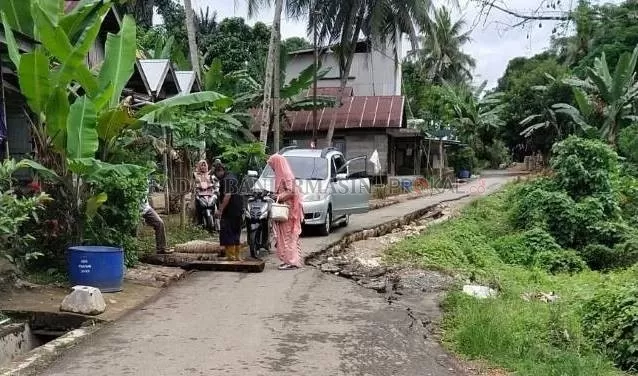 BELUM DIPERBAIKI: Mobil terpaksa harus berhenti karena satu potongan batang kelapa yang menutupi got terjatuh. | FOTO: WAHYUDI/RADAR BANJARMASIN.