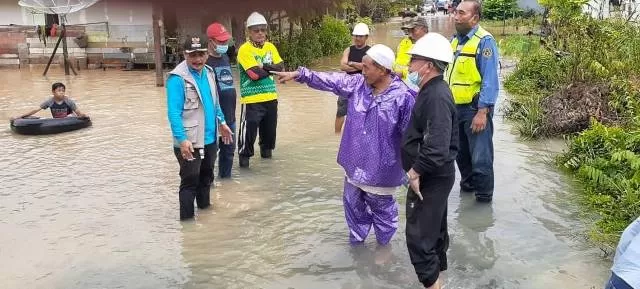 SUDAH SURUT: Petugas Kecamatan Satui gotong royong membersihkan rumah waga yang terdampak banjir.