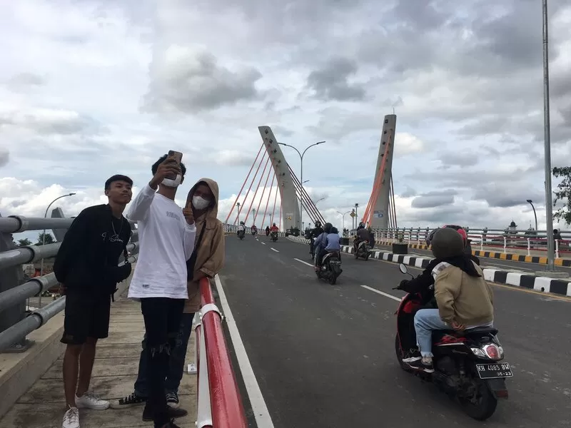 JEMBATAN MEGAH: Begitu Jembatan Sungai Alalak Dibuka Untuk Umum, warga langsung menyerbu demi ingin berswafoto. Foto: Muhammad Oscar Fraby/Radar Banjarmasin