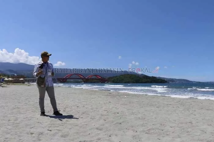 PAKET LENGKAP: Hamparan pasir putih pantai Cibery yang dikombinasikan dengan megahnya Jembatan Merah dan pegunungan adalah spot foto sempurna pengunjung di pantai Cibery. | Foto: M IDRIS JIAN SIDIK/Radar Banjarmasin
