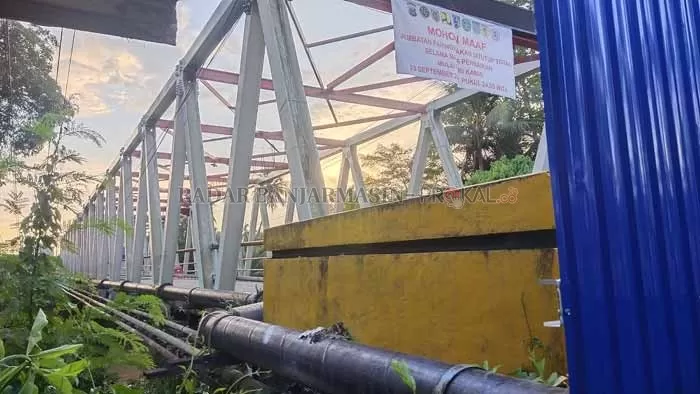 MENEMPEL: Penyangga pipa PDAM Kabupaten Balangan yang menempel di lantai Jembatan Paringin harus dibongkar untuk kelancaran perbaikan jembatan. | FOTO WAHYUDI RADAR BANJARMASIN.