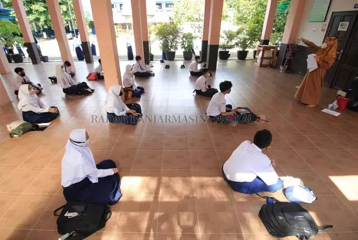 LESEHAN: Aktivitas belajar mengajar di SMPN 1 Banjarbaru menerapkan sistem belajar di luar ruangan semasa PTM perdana digelar. | Foto: Muhammad Rifani/Radar Banjarmasin