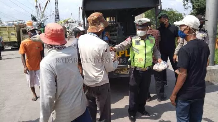JUMAT BERKAH: Sambil berpatroli Polisi membagikan nasi bungkus kepada buruh di Pelabuhan Trisakti Banjarmasin.