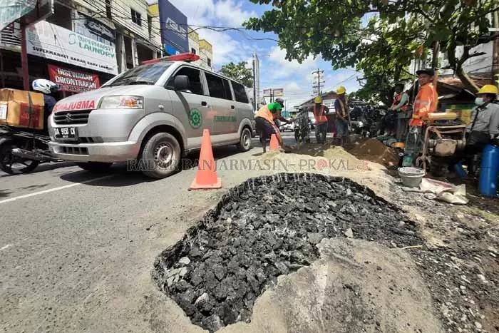 DIBENAHI: Jalan yang amblas di kawasan Jalan Kampung Melayu Darat, Senin (18/10) siang mulai diperbaiki. | Foto: Wahyu Ramadhan/Radar Banjarmasin