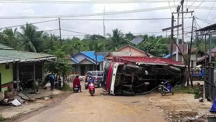 EVAKUASI : Kondisi truk yang terbalik di Jalan Garuda Maharam, Paringin, Kabupaten Balangan, belum dievakuasi hingga sekitar pukul 11.00 Wita.  FOTO WAHYUDI RADAR BANJARMASIN.