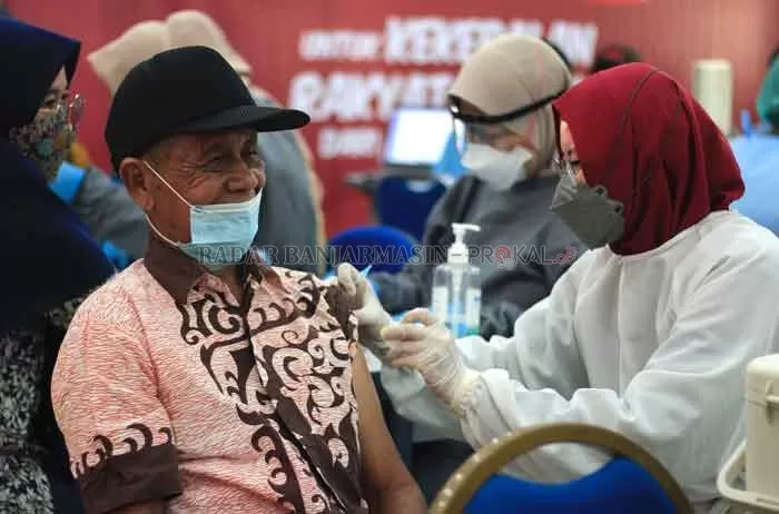 TERSENYUM: Petugas medis menyuntikkan vaksin kepada salah seorang lansia di Banjarbaru tak lama tadi. Vaksinasi lansia di Banjarbaru tergolong tinggi dibanding daerah lain di Kalsel. | Foto Muhammad Rifani/Radar Banjarmasin